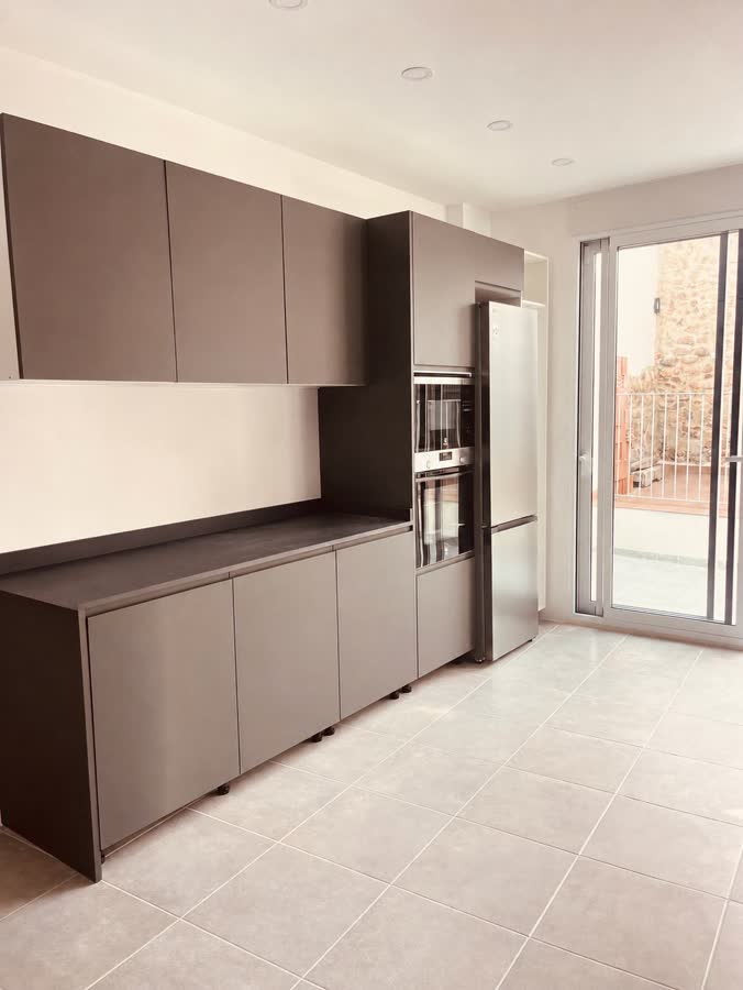 Cocina con muebles antracita mate y salida a la terraza