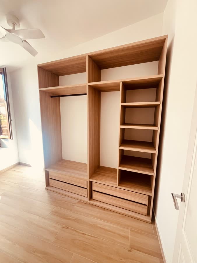 Módulo de vestidor abierto en madera clara con cajones y baldas