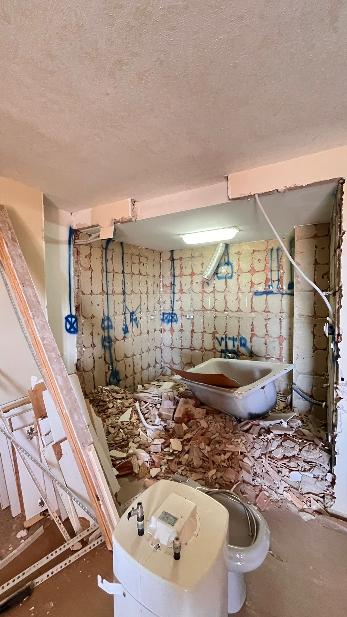 Cocina durante la reforma — vivienda en obra, con tabiquería e instalaciones al descubierto